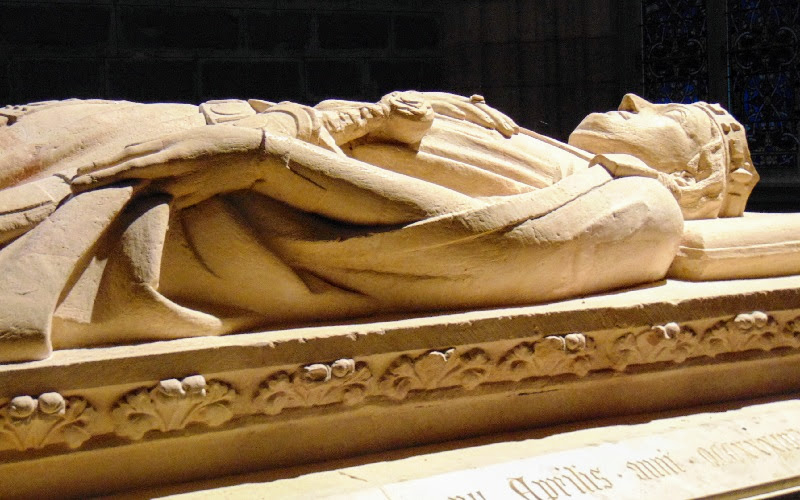 escultura do rei morto. em pedra clara. sobre uma lápide