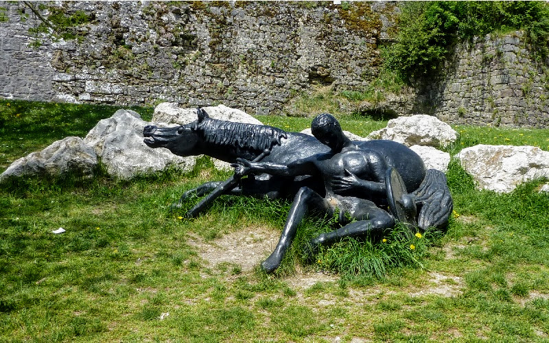 escultura de um homem reclinado sobre um cavalo deitado