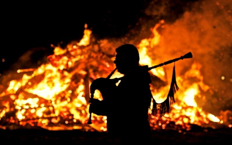 tocador de gaita galega em frente a uma fogueira