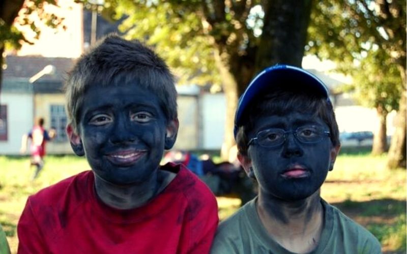 duas crianças com os rostos pintados com cinzas