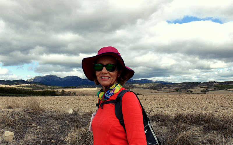 mulher com chapéu e óculos de sol em paisagem natural árida