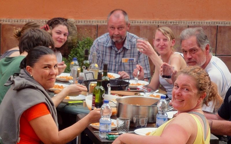 grupo de pessoas compartlhando uma refeição em torno de uma mesa