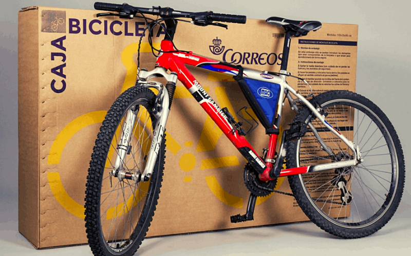 bicicleta vermelha diante de uma caixa de transporte