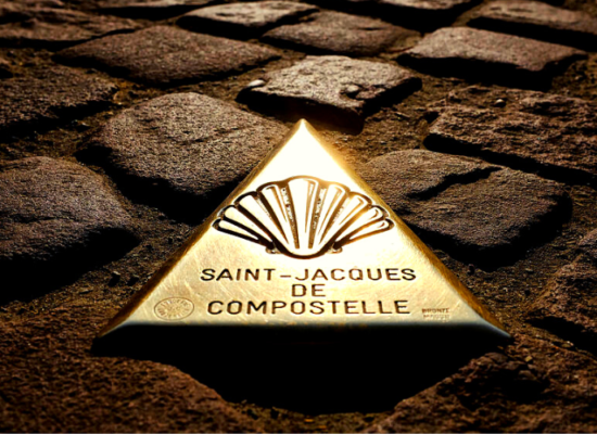 piso de pedras com uma placa triangular de metal onde está gravada uma concha e as palavras saint-jacques de compostelle