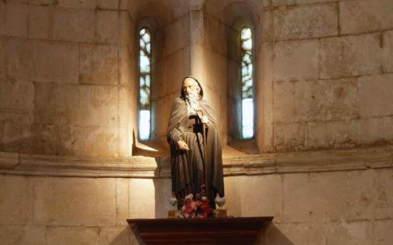 imagem de san juan de ortega sobre uma pilastra tendo ao fundo duas janelas