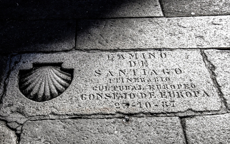 piso em pedra onde está esculpida uma pedra e os dizeres: camino de santiago itinerario cultural europeo - consejo de europa - 23 /10 /87