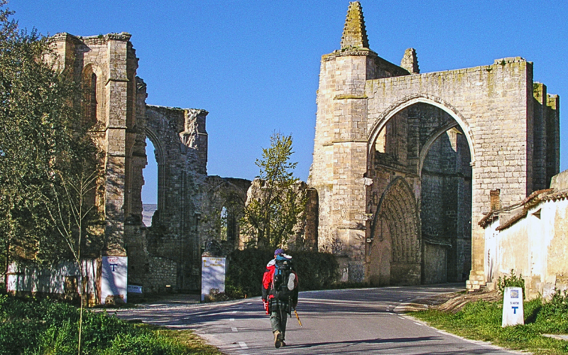 peregrino de aproximando das ruinas de um antigo mosteiro em dia de céu azul