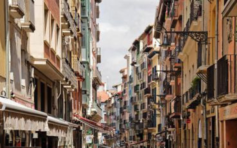 rua estreira, cheia de edifícios de tamanho mediano e pintados de cores variadas 