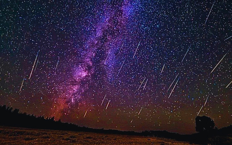 chuva de meteoros em um céu azul de tons lilás e rosa