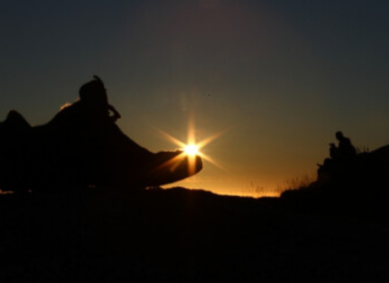 silueta de uma bota com o sol no horizonte