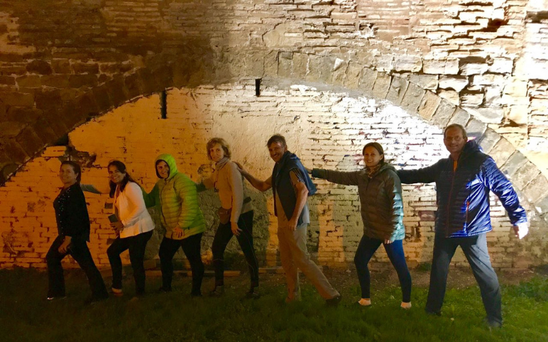 grupo de pererginos em fila em frente a uma muralha medieval