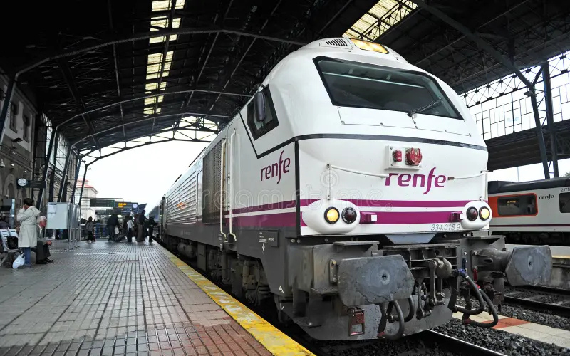 um trem branco da renfe parado na plataforma da ferroviária de santiago de compostela